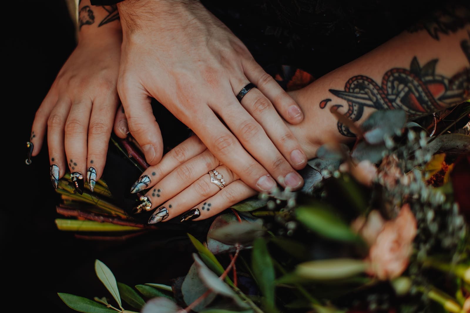 The newlyweds' hands placed on top of a bouquet