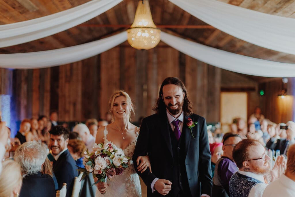 The newlyweds walk through their wedding breakfast arm in arm