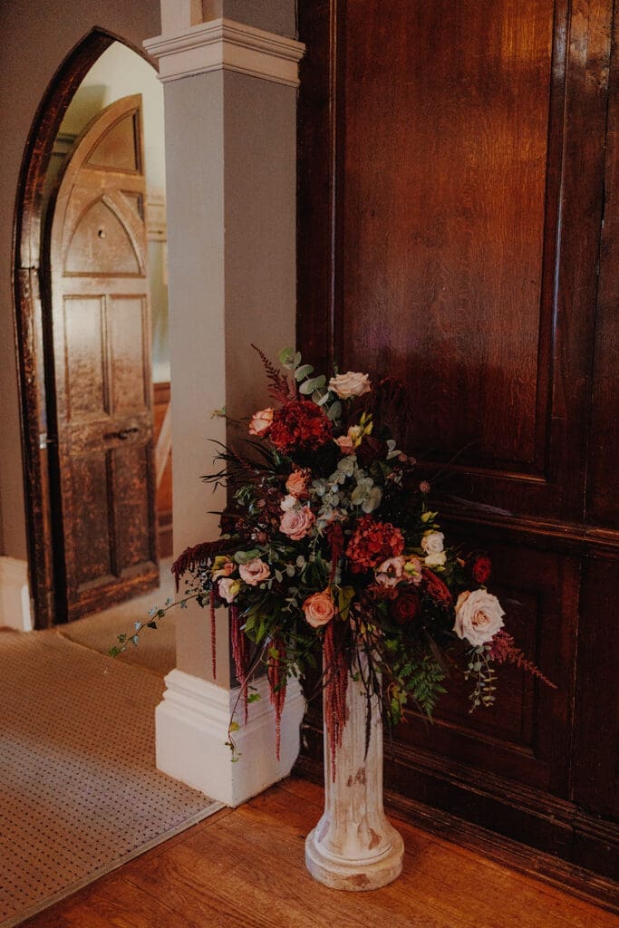 A gorgeous arrangement of flowers on a small pillar
