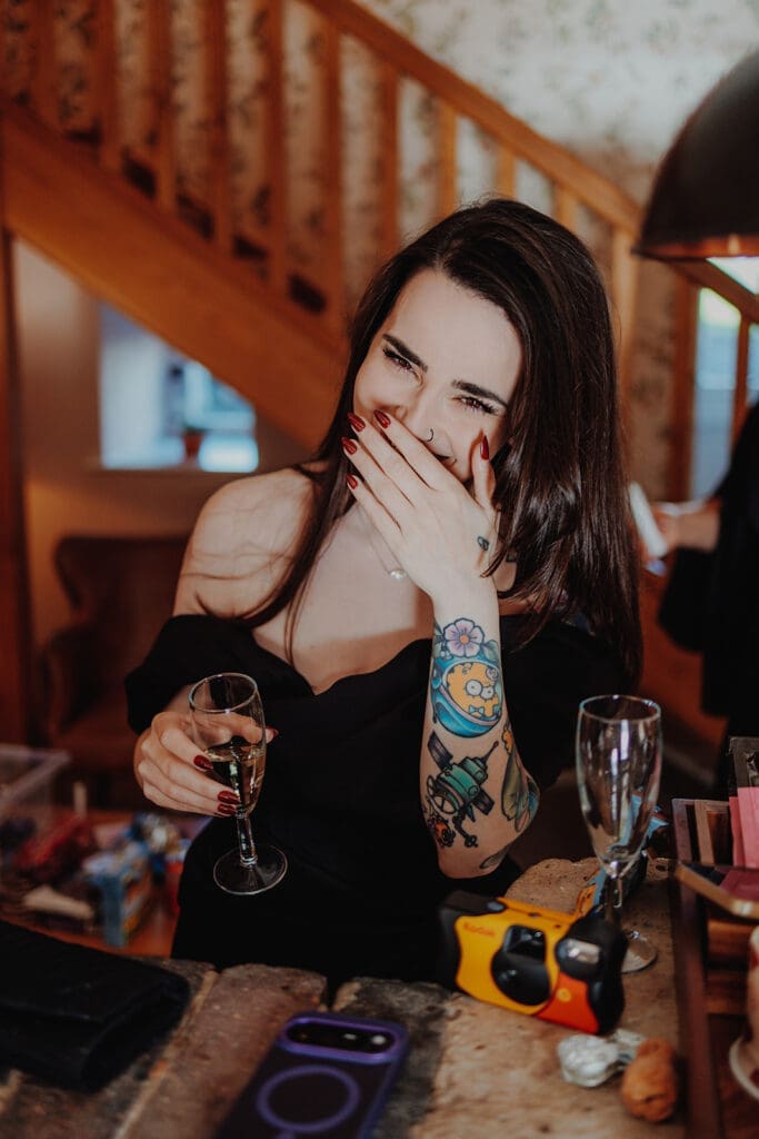 A bridesmaid giggles holding a glass of prosecco